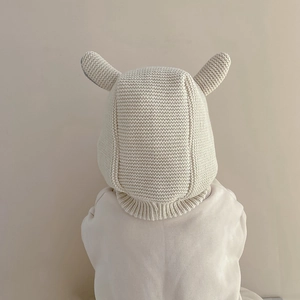 Détails de la maille et oreilles d'animaux sur ce bonnet d'hiver crème pour bébé