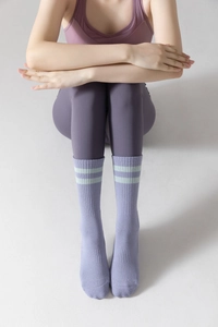 Detail of purple mid-calf yoga toe socks with light green stripes on premium knit fabric