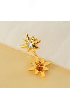 Detail of 18K gold plated octagonal star earrings with a central clear zircon stone
