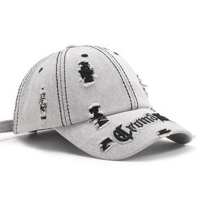 Distressed light gray denim baseball hat with ripped holes and black Gothic embroidery