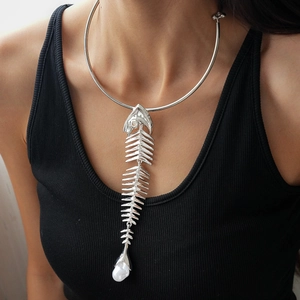 Detailed view of silver fishbone necklace with rhinestones and pearl drop on model