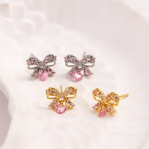 Detailed view of pink teardrop crystal earrings with bow design in gold and silver finish