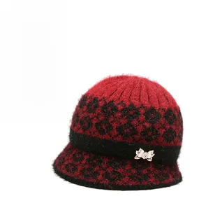 Close-up of winter knit bucket hat with leopard pattern and rhinestone bow detail