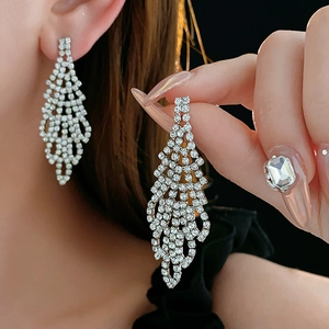 Close-up of sparkling silver tassel earrings with high-quality rhinestones on black background