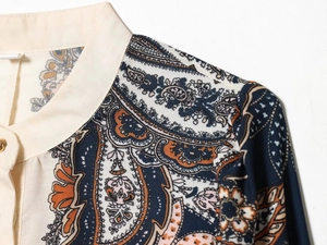 Detaillierte Nahaufnahme des Paisley-Hemdkragens mit eleganten goldenen Rundknöpfen