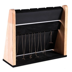 Macro side view of multi-layer wood and black velvet necklace display stand for jewelry