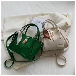 Vue détaillée des sacs seaux en cuir avec fermoirs métalliques et poignées en foulard