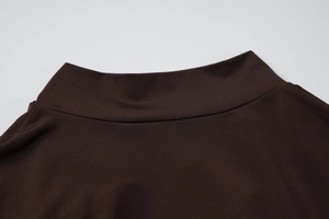 Gros plan du col en maille côtelée marron chocolat montrant les coutures et la texture