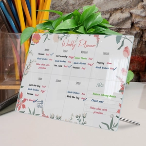 Macro detail of acrylic weekly planner with floral patterns and sturdy metal stands