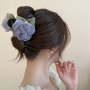 Détail de la grande pince à cheveux fleur en dentelle grise et bleue pour coiffures élégantes