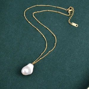 Fashion 18K gold-plated necklace with irregular white baroque pearl on green background