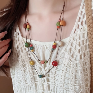 Dettaglio della collana bohémien a doppio strato con perle di ceramica colorate e cordino