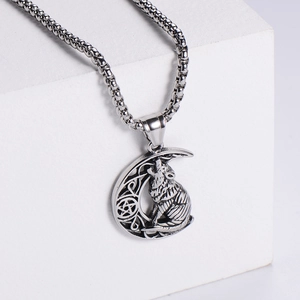 Macro detail of antique silver wolf howling at moon pendant with gothic hollowed-out texture