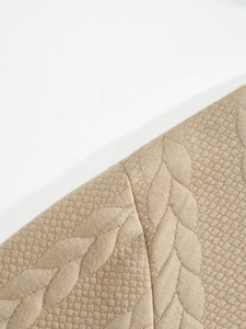 Detailed macro view of khaki knit fabric featuring cable knit and rhombus patterns