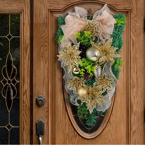 Detail eines goldenen Weihnachts-Tuerhaengers mit Schleife auf einer Holztuer