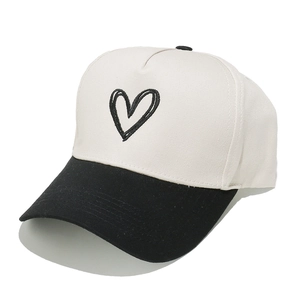 Two-tone five-panel trucker hat featuring black heart embroidery on white canvas