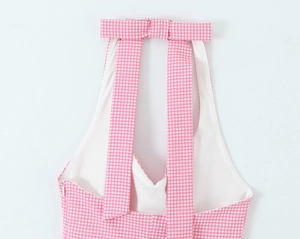 Detailed view of pink plaid halter top featuring a back bow tie and zipper closure