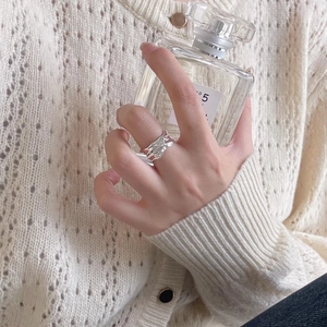 Irregular fluid texture S925 sterling silver ring worn by model with textured knitwear