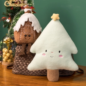Festive gingerbread house and Christmas tree plush toys on a decorated sofa