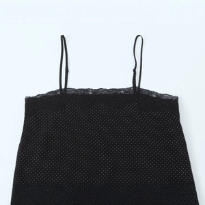 Polka dot camisole with black lace trim and spaghetti straps in a flat lay view