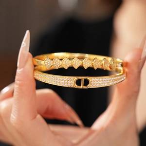 Detail of gold plated D-letter bangle with micro-pave cubic zirconia fan charms