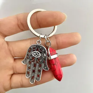 Detailed shot of Hamsa hand charm with red hexagonal stone pendant on key ring