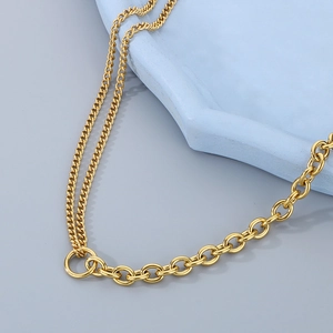 Minimalist gold mixed cuban and cable chain necklace on a ceramic display tray