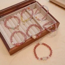 Detail showing pink strawberry quartz beaded bracelets with cute rabbit charm in jewelry box