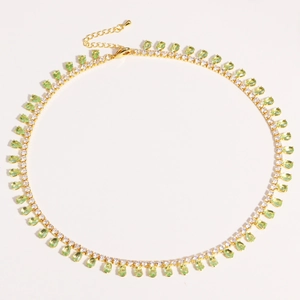 Detail of gold-plated necklace with green pear-cut stones and sparkling zircon fringe