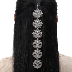 Dettaglio della catena per capelli etnica argento con cristalli su capelli neri