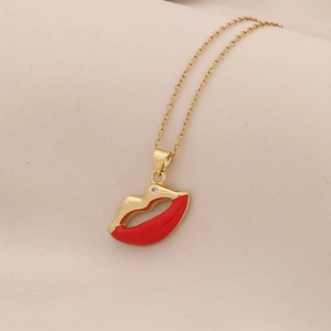 Detail van de gouden lippen hanger met rood emaille en kleine diamant accenten