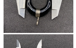 Calipers measuring the inner and outer diameters of wire-wrapped horn moon pendant