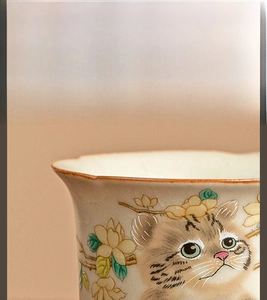 Macro detail of Ru kiln ceramic teacup with cat motif and ice-crackle glaze texture