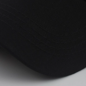 Macro detail of high-density cotton twill fabric and parallel stitching on a black cap