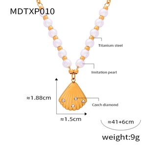 Detail view of gold shell pendant with crystals and pearl bead titanium steel chain