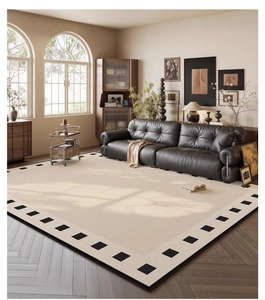 Detail of chenille rug texture with black square border on herringbone floor