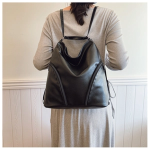 Black PU leather backpack shown on a model for scale and daily wear perspective
