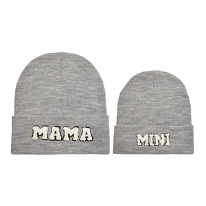Dettaglio di berretti in maglia grigi con toppe MAMA e MINI per genitore e bambino