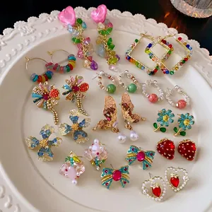 Bunte Blumenohrringe mit Herzperlen, Perlen und Schmetterlingsanhängern in Keramikschale