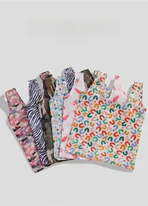 Close-up showing multiple patterns of folding eco-friendly shopping bags in various prints