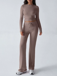 Detail view of brown Y2K tracksuit featuring drawstring wide-leg pants and crop long sleeve top