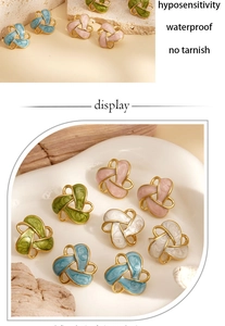 Detail view of colorful enamel flower earrings with gold trim and knot design on ceramic