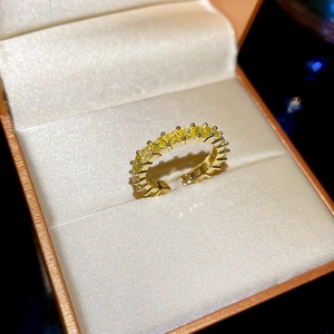 Close-up of 18k gold plated open ring with a row of sparkling yellow zircons
