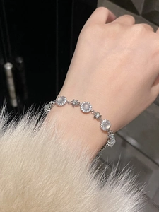 Close-up of zircon chalcedony flower bracelet with silver star charms on a model wrist