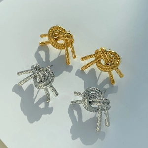 Set of gold and silver knot earrings with spiral twisted rope texture on a card