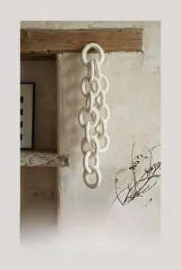 Close-up of matte white ceramic chain rings hanging from a wooden beam in Wabi-sabi style