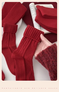 Detailed view of red knitted cotton crew socks with geometric jacquard patterns