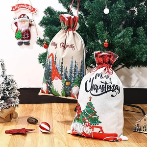 Christmas burlap drawstring gift bag with festive gnome and forest print on wood floor