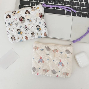 Detail of quilted floral storage bags with dog patterns on a minimalist white desk setup