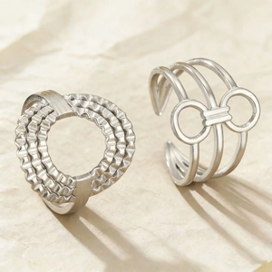 Detailed shot of textured heart-shaped ring and triple band bow ring in silver